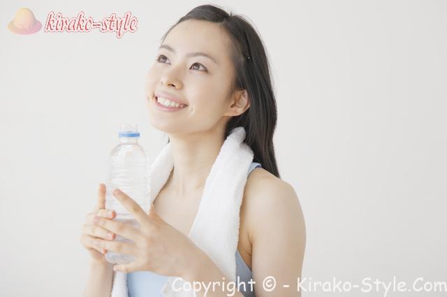 汗をかいてペットボトルで水分補給する女性